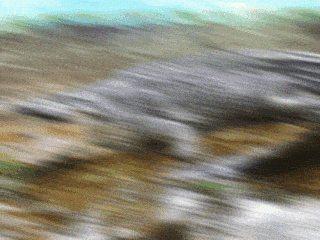 a blurry picture of a river with a blue sky