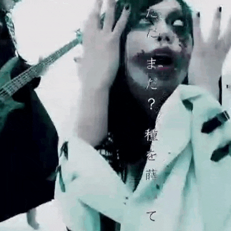 a woman with blood on her face is holding her hands up in front of a guitar .