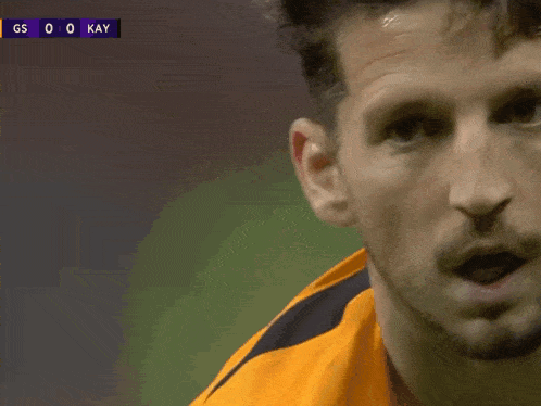 a close up of a man 's face in front of a scoreboard that says gs 0-0 kay