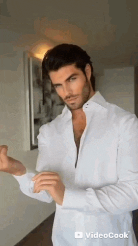 a man in a white shirt is adjusting his cuffs .