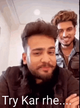 a man with a beard and mustache is smiling and talking to another man .