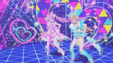 two anime girls are dancing on a stage with hearts and triangles in the background