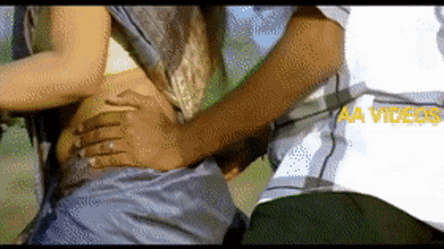 a video of a man holding a woman 's stomach with the words aa videos written on the bottom