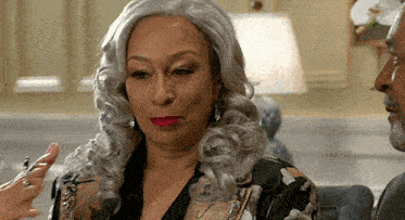 a woman with gray hair and red lips is sitting next to a man