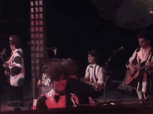 a group of people playing instruments on a stage with a sign that says zos