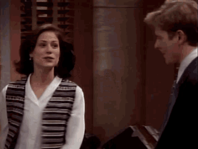 a man and a woman are standing next to each other in a room