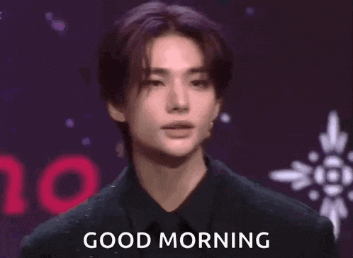 a young man is making a heart shape with his hands and saying good morning .