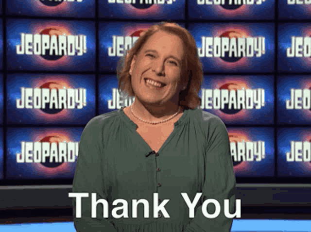 a woman stands in front of a screen that says jeopardy and says thank you