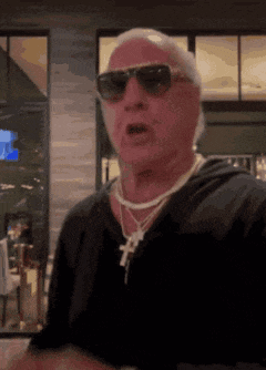 a man wearing sunglasses and a cross necklace