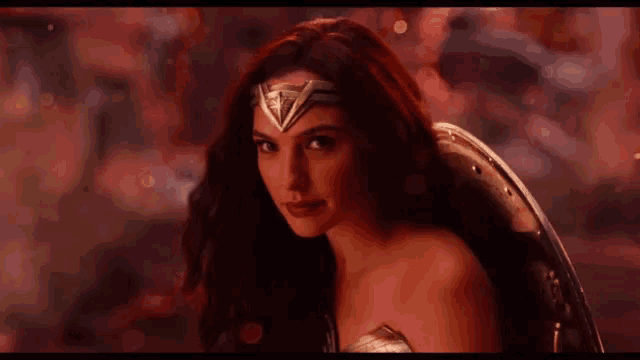 a woman in a wonder woman costume is looking at the camera