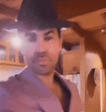 a man wearing a cowboy hat and a pink shirt