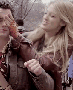 a woman is covering a man 's eyes with her hand