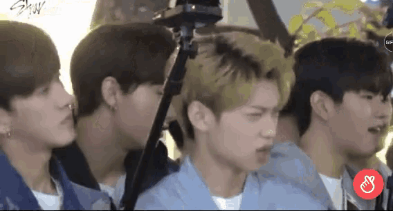 a group of young men are standing next to each other and looking at something .