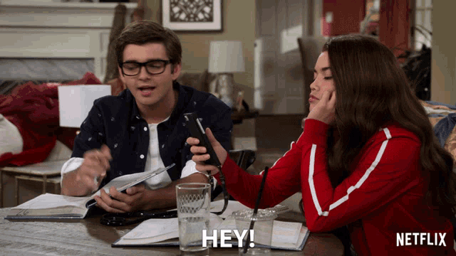 a man and a woman sit at a table with a netflix logo on the bottom right
