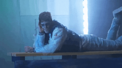 a zombie is laying on a bench in a dark room