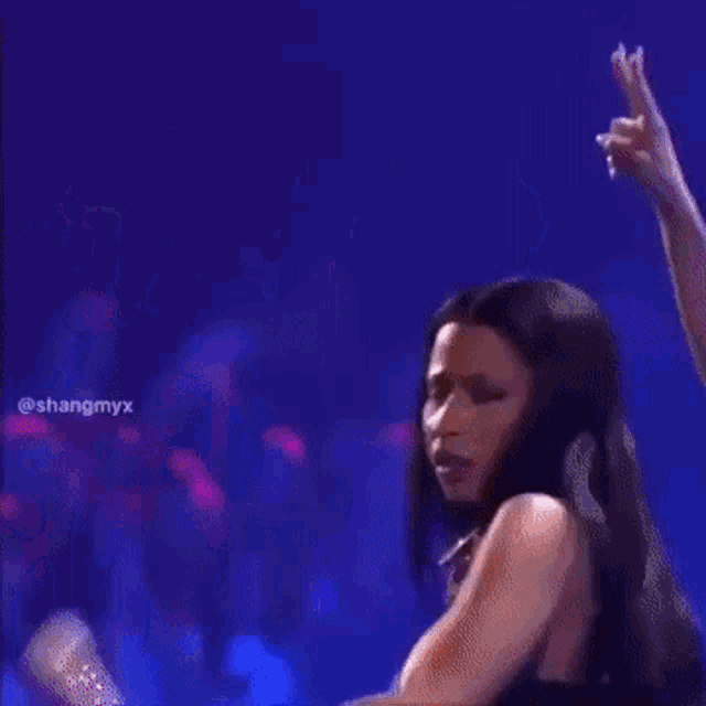 a woman in a floral dress is dancing on stage .