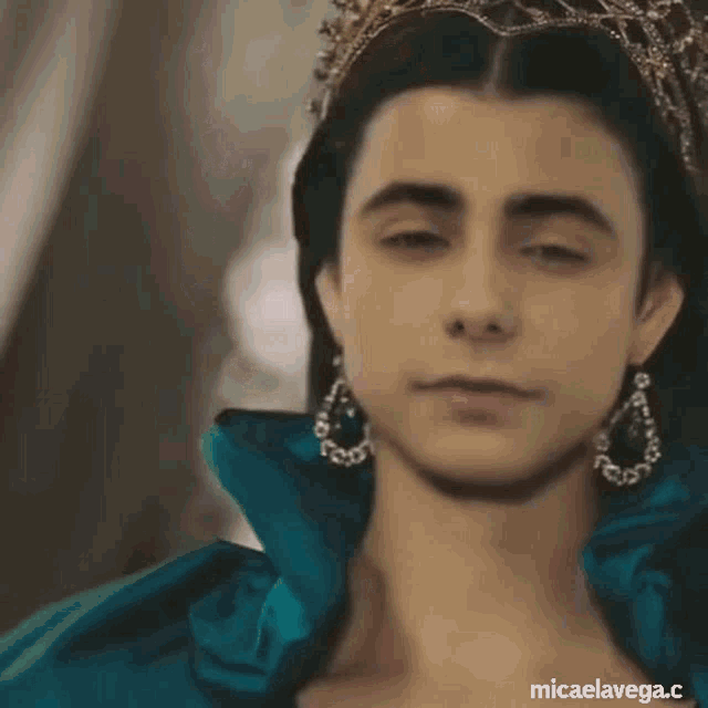a close up of a woman wearing a blue dress and a tiara
