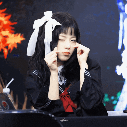 a girl in a school uniform with a white bow on her hair