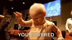 a baby is standing in front of a screen that says you covered