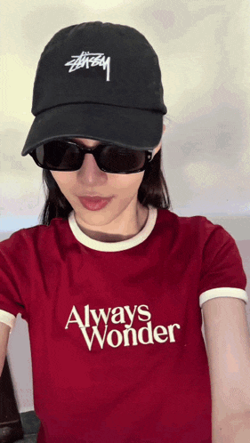 a woman wearing a red shirt that says always wonder on it