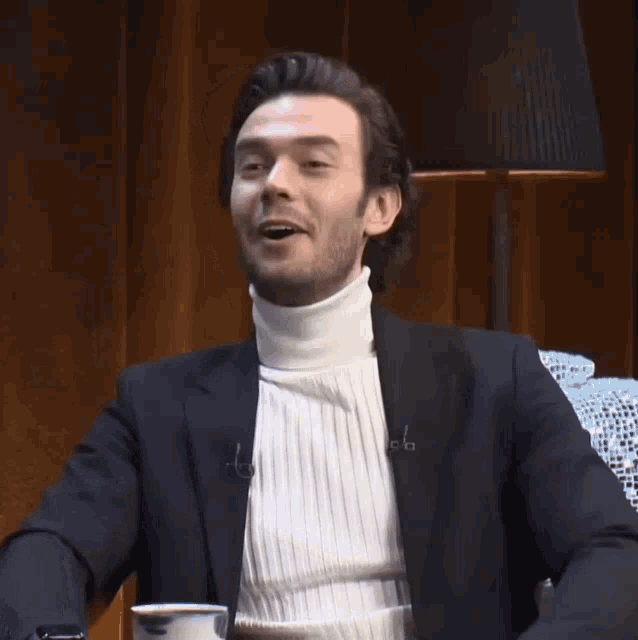 a man wearing a turtleneck and a black jacket