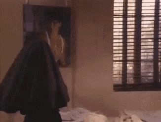 a man is standing in a bedroom with a painting on the wall .
