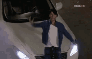 a man is standing in front of a white car that says mbchd on it