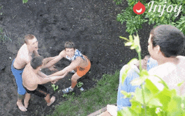 a group of young men are playing in the dirt with a trijoy logo behind them
