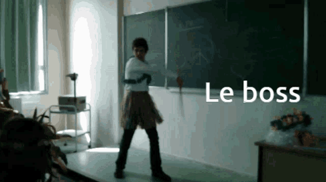 a person standing in front of a blackboard with the word le boss written on it
