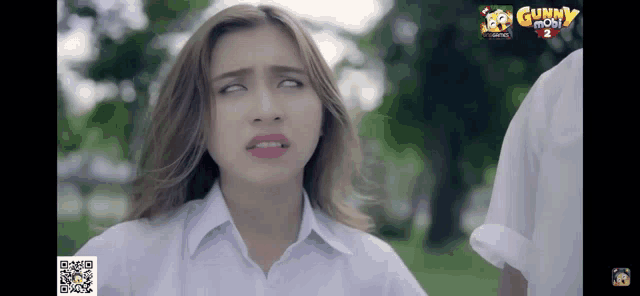 a girl is making a funny face in front of a gunny mobi 2 logo