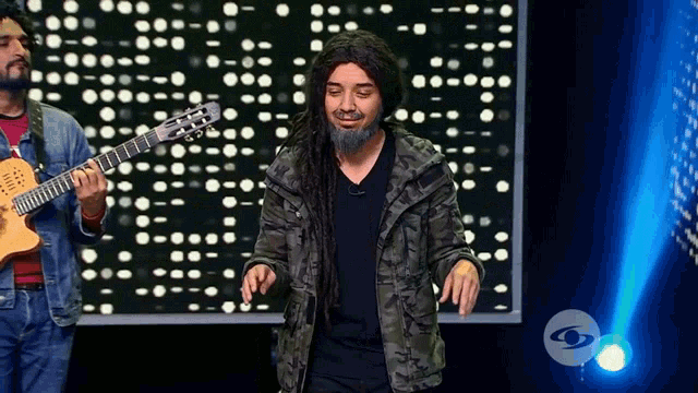 a man with dreadlocks and a beard is playing a guitar that says ' yamaha ' on the neck