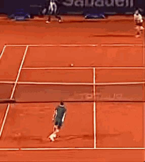 a tennis match is being played on a clay court