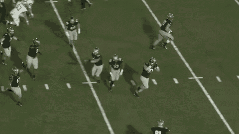 a group of football players are running on a field with the ball .