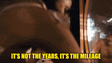 a man is standing in front of a mirror with the words it 's not the years it 's the mileage