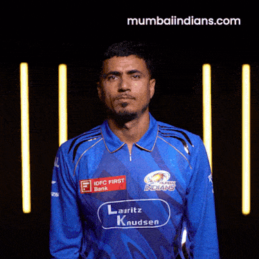 a man is wearing a blue shirt that says mumbai indians on it