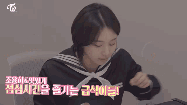 two girls are sitting at a table with a twice tv logo in the corner