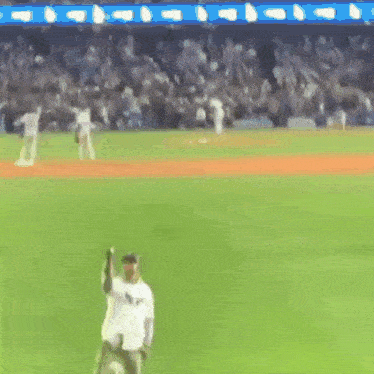 a blurry picture of a baseball game with a player wearing a white jersey that says ny