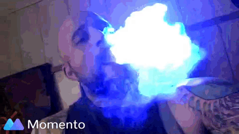 a man is blowing blue smoke out of his mouth and the word momento is on the bottom right