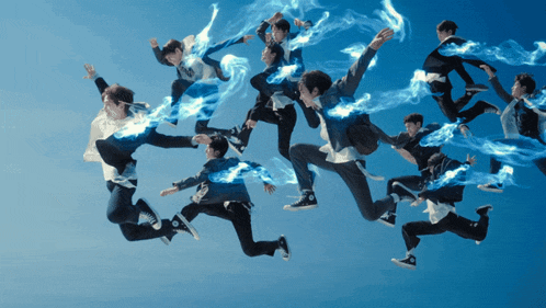 a group of people jumping in the air with smoke coming out of their feet