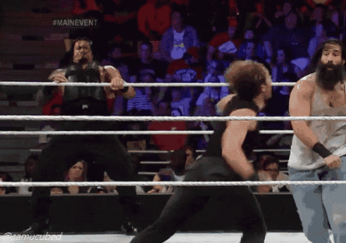 two wrestlers in a ring with a sign that says main event