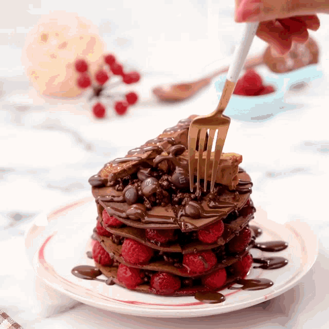 a person is holding a fork over a stack of chocolate pancakes