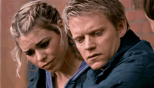 a man and a woman are looking at something together