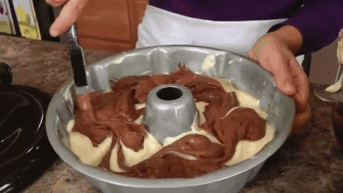a bundt cake with chocolate frosting is being filled with a knife