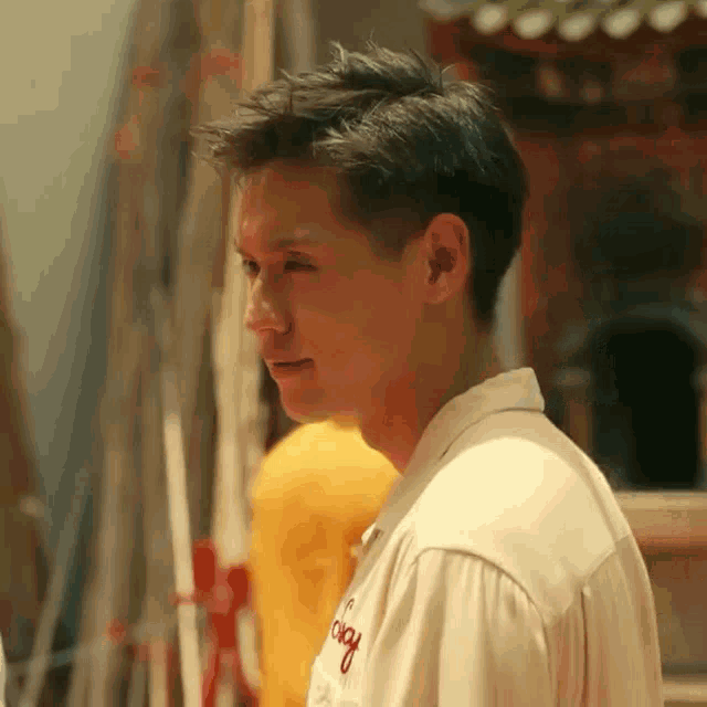 a man wearing a white shirt with a red embroidery that says tokyo