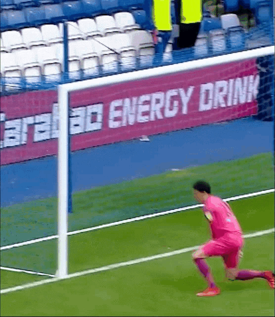 a soccer goalie in front of an energy drink sign