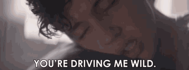 a man is laying in bed with his eyes closed and the words `` you 're driving me wild '' written above him .