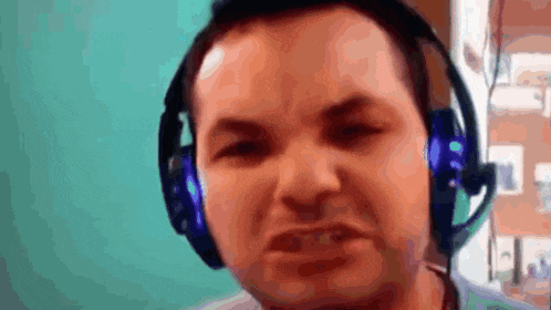 a man wearing headphones and a microphone makes a funny face