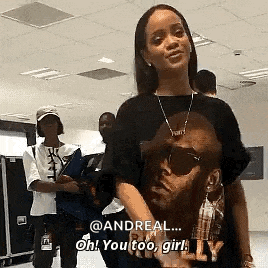a woman wearing a t-shirt with a picture of a man on it is talking to a man named andreal