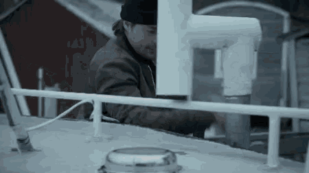 a man wearing a beanie is working on a pipe