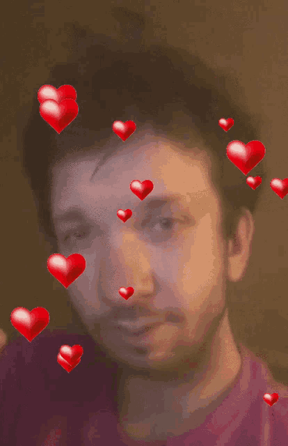 a man in a pink shirt is surrounded by hearts